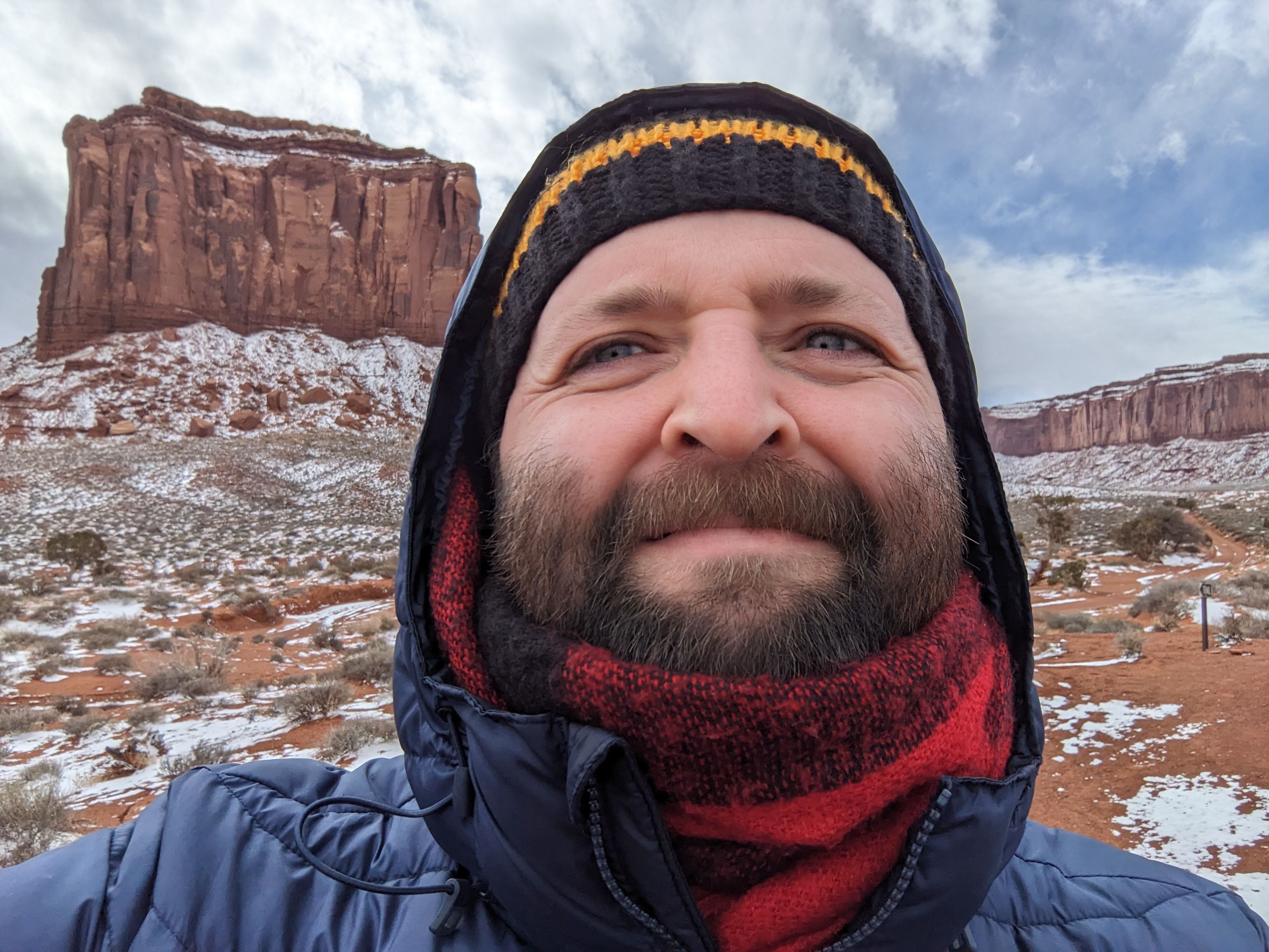 The site's author in front of a flat-topped mesa covered in snow